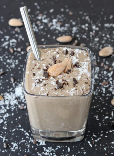 Short glass with chocolate smoothie, sprinkled with coconut and chocolate