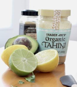 Tahini, lemon, lime, avocado and garlic powder. Showing ingredients for Tahini Avocado Dressing
