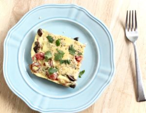 Blue plate with egg casserole and fork.