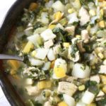 Close up to chicken, potato and cilantro soup on a white napkin.